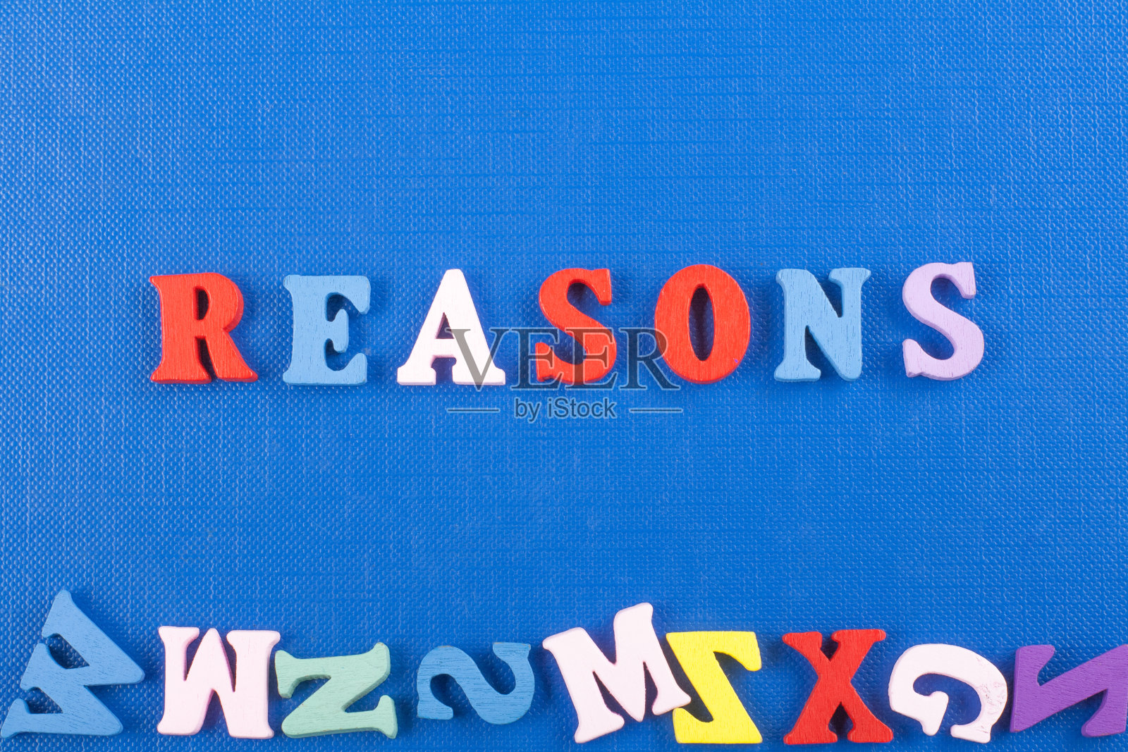 蓝色背景字由彩色abc字母表块木制字母组成，为广告文字提供复制空间。学习英语的理念。照片摄影图片