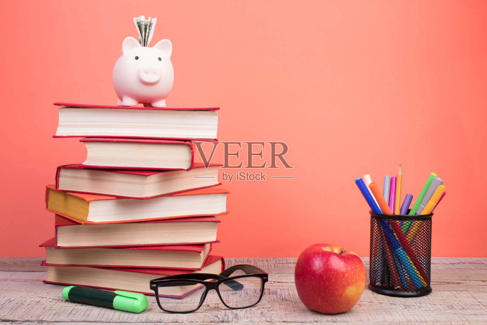 构图与精装书，扇页在木制甲板桌和橙色背景。书堆积。回到学校。副本的空间。教育背景。照片摄影图片