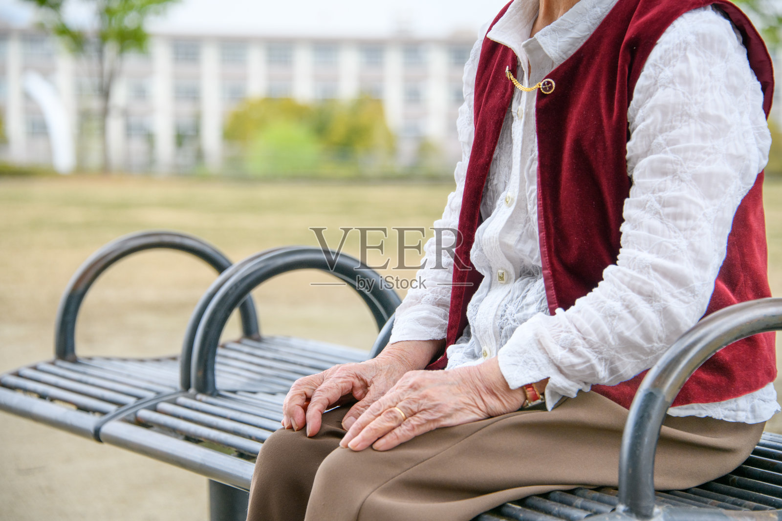 坐在公园长椅上的日本老妇人照片摄影图片