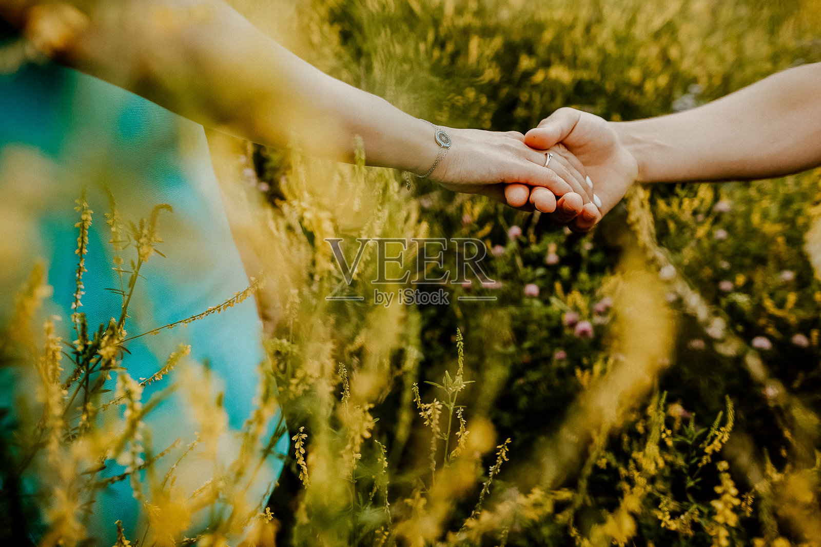 一男一女伸手相接，两人牵手，友谊的概念，伸出援助之手，背景模糊，户外照片摄影图片