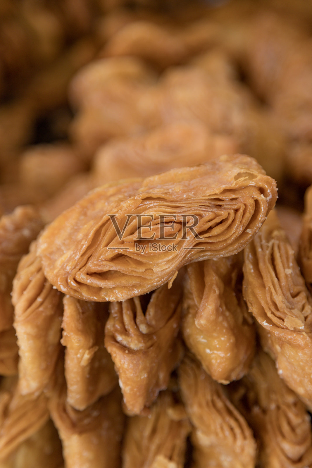 在印度的普里奥里萨邦出售的Khaja小吃将油酥饼分层浸泡在糖浆中。照片摄影图片