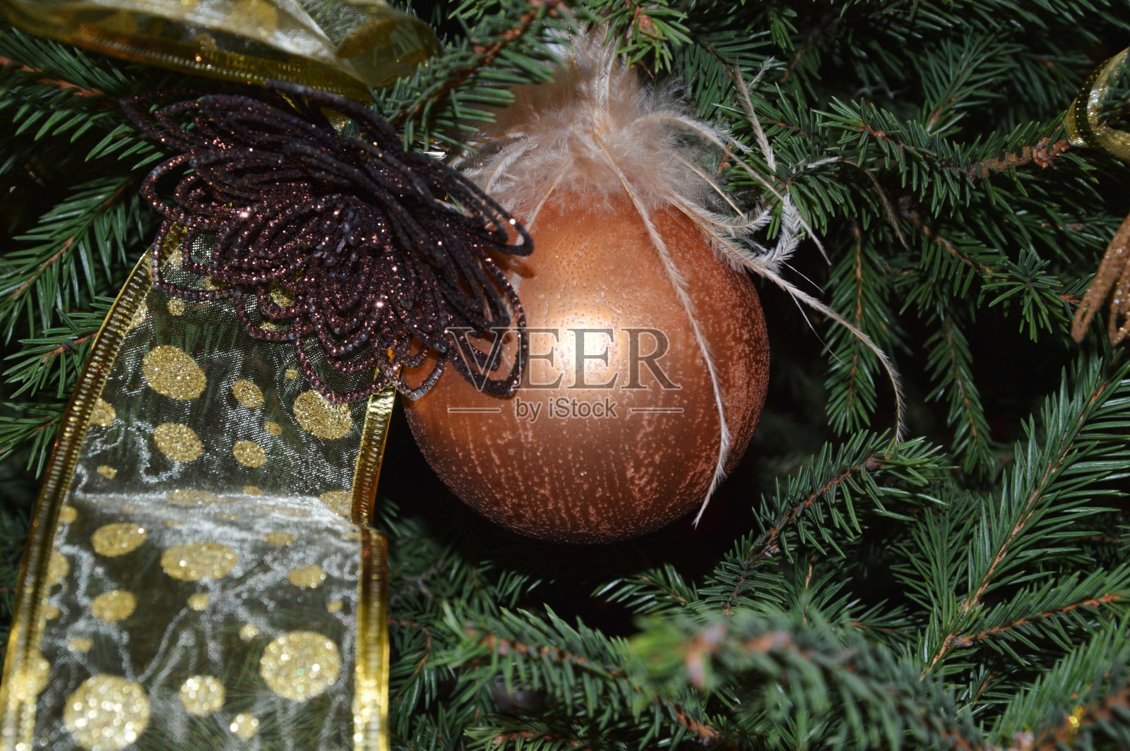 以圣诞树为背景的金色彩带球。喜庆新年背景。照片摄影图片
