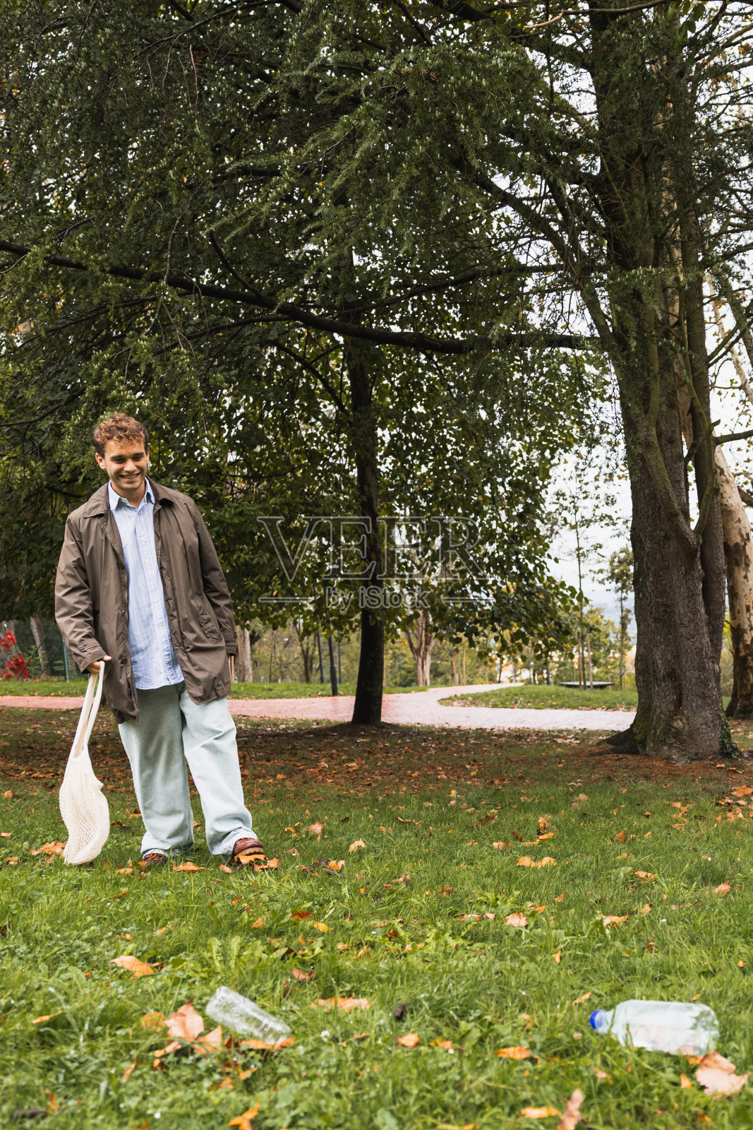 小男孩在公园里为回收塑料散步照片摄影图片