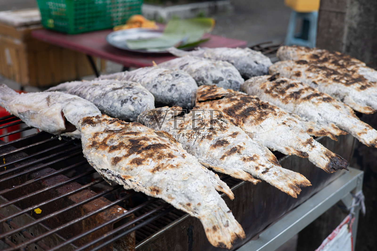 在铁锅上烤鱼是泰国的街头小吃。照片摄影图片
