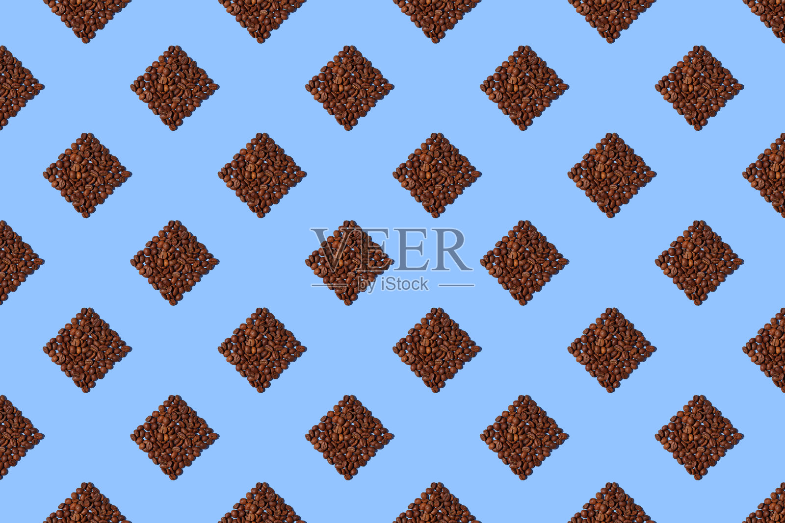 蓝色背景上的咖啡色方块。以正方形的形式倒入咖啡豆的无缝图案。照片摄影图片