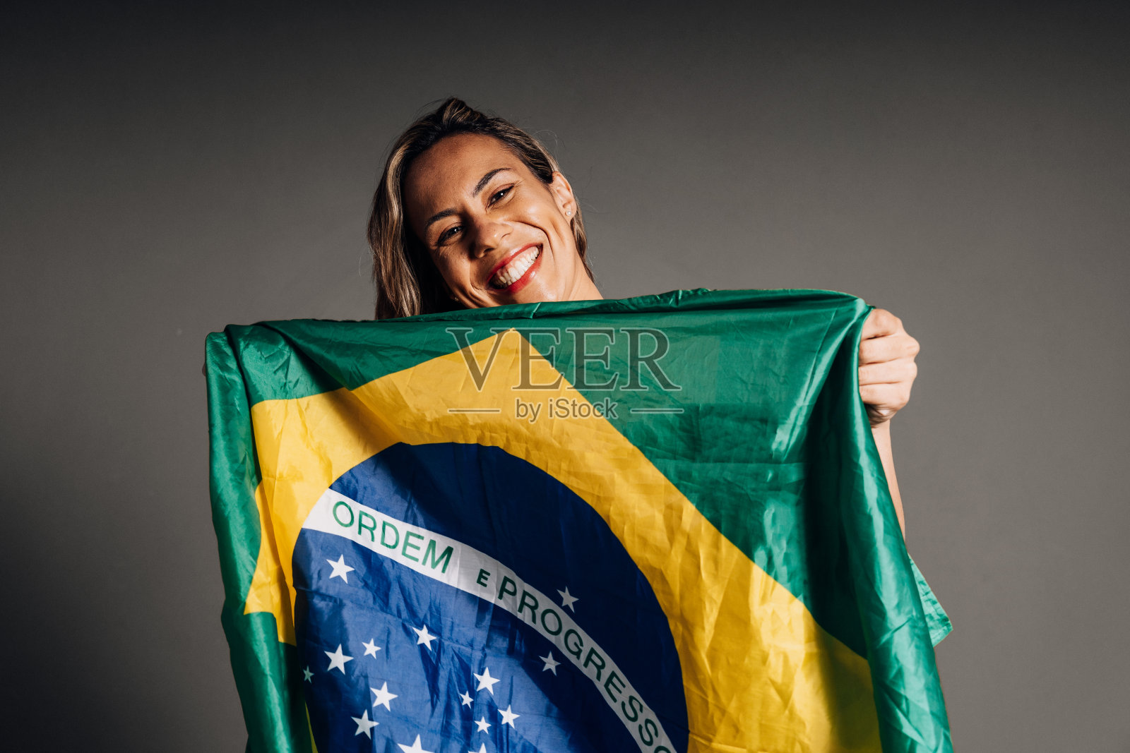 拿着巴西国旗微笑的女人照片摄影图片