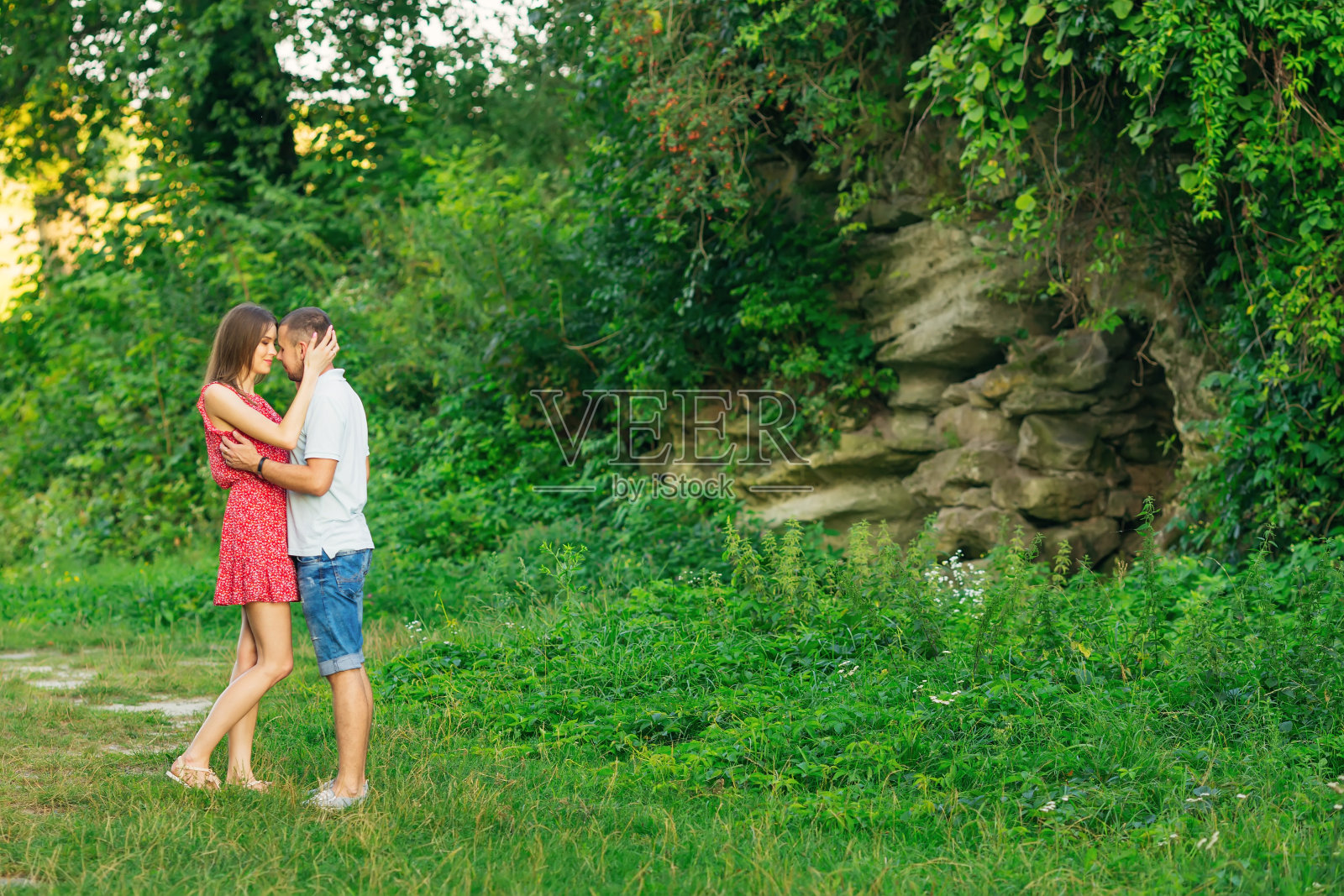 美丽的情侣拥抱在岩石的背景下，照片摄影图片