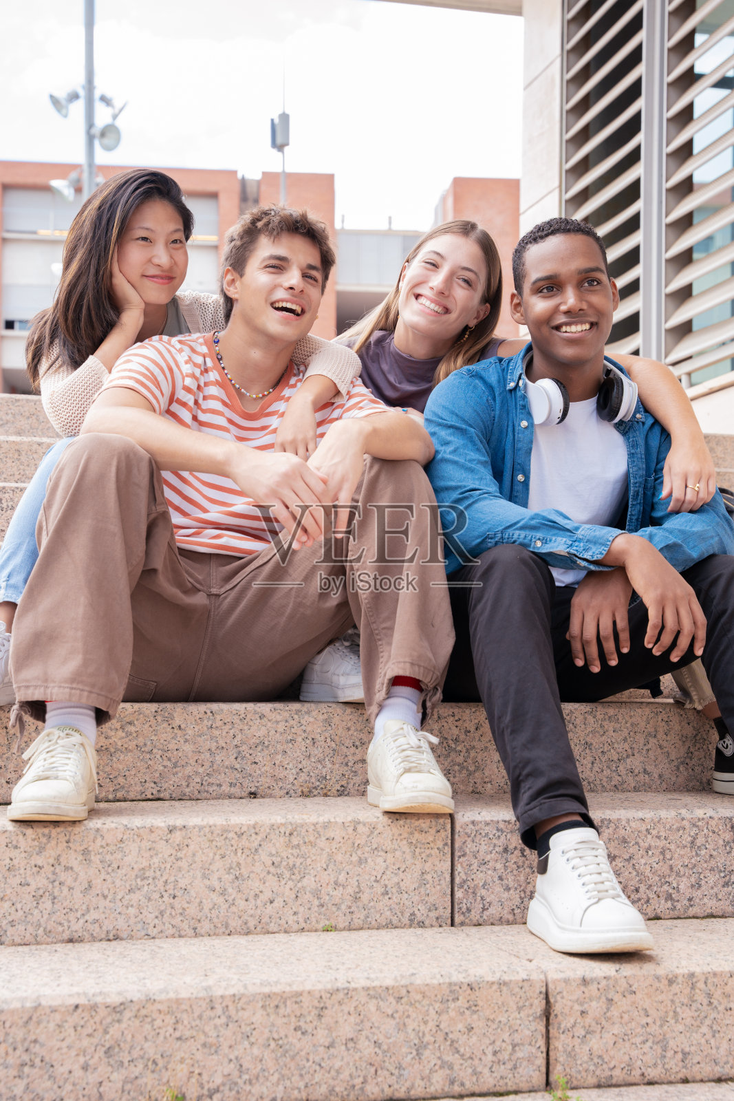 快乐的多民族青年朋友在户外聚会。照片摄影图片