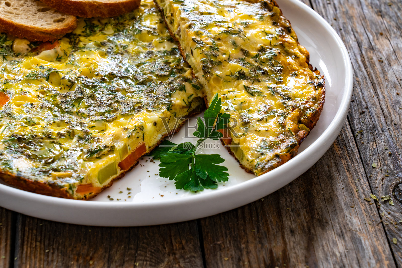 煎蛋卷——在木桌上用奶酪和蔬菜炒鸡蛋照片摄影图片