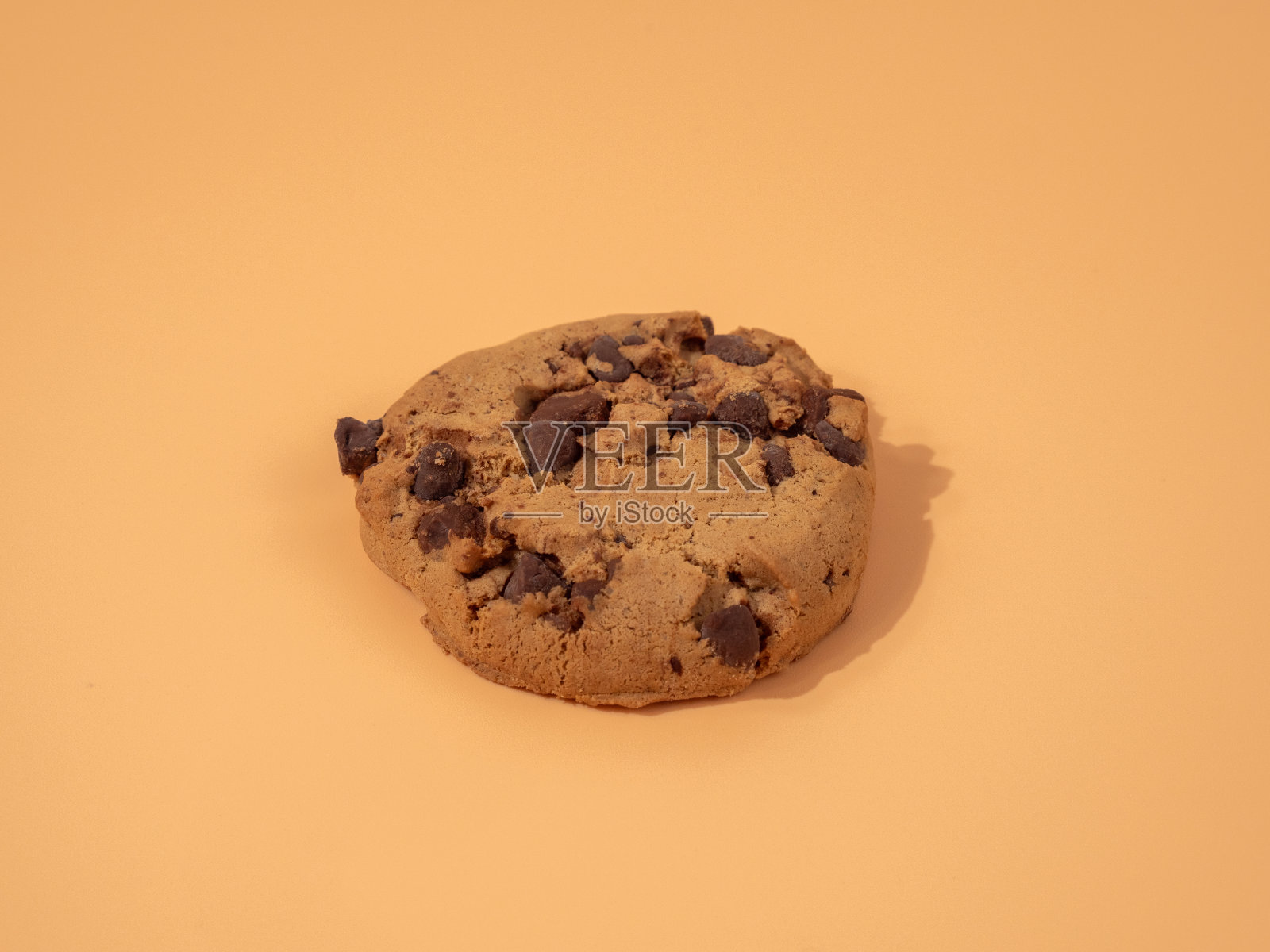 橙色背景的巧克力片燕麦饼干。照片摄影图片