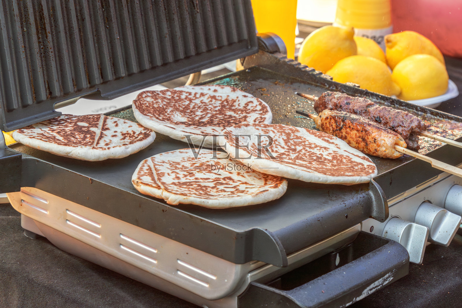在街边的咖啡馆里用电烤架烤面包饼和烤肉串。特写镜头照片摄影图片
