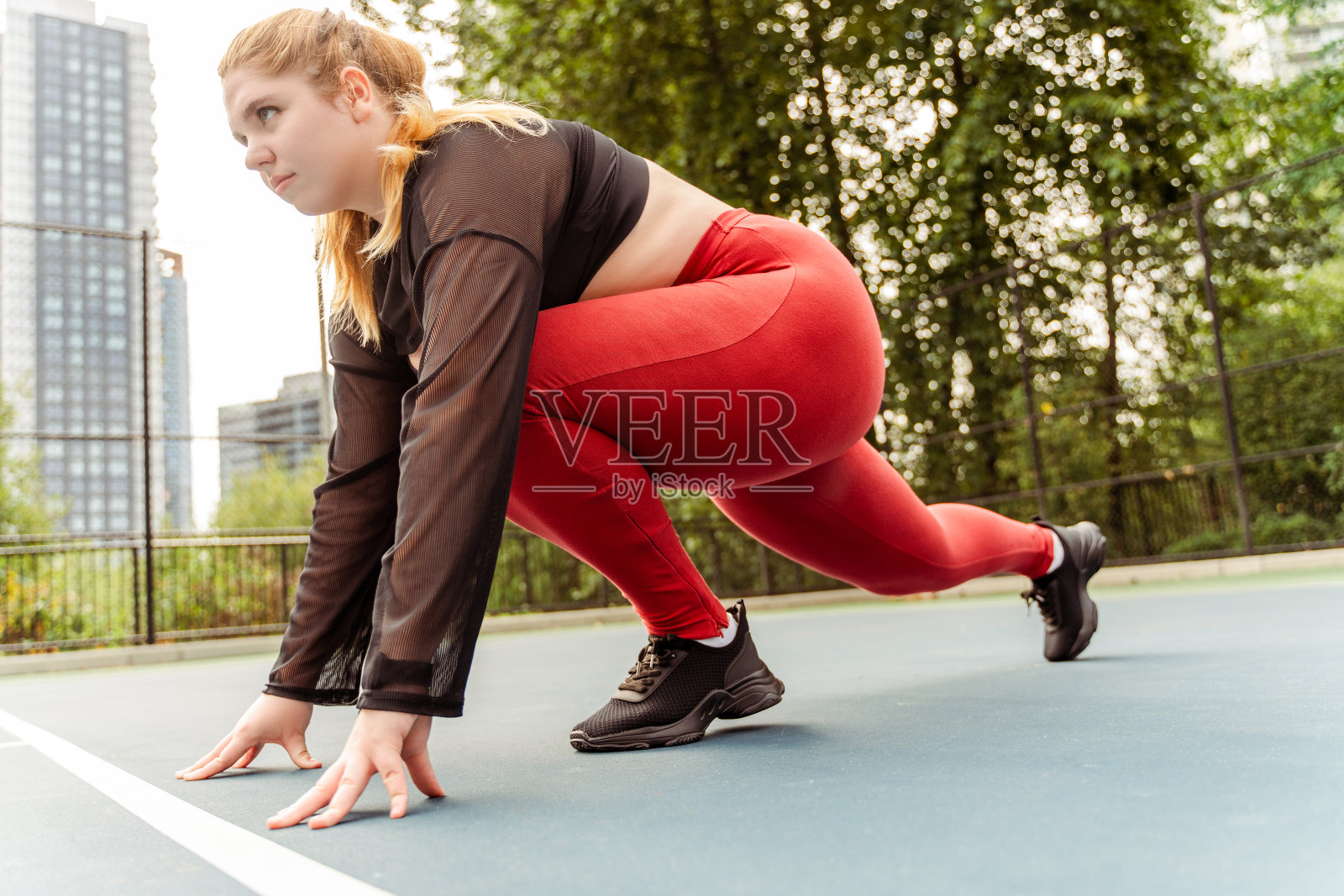 年轻女子在户外跑道上开始跑步。大码模特，激励，训练照片摄影图片
