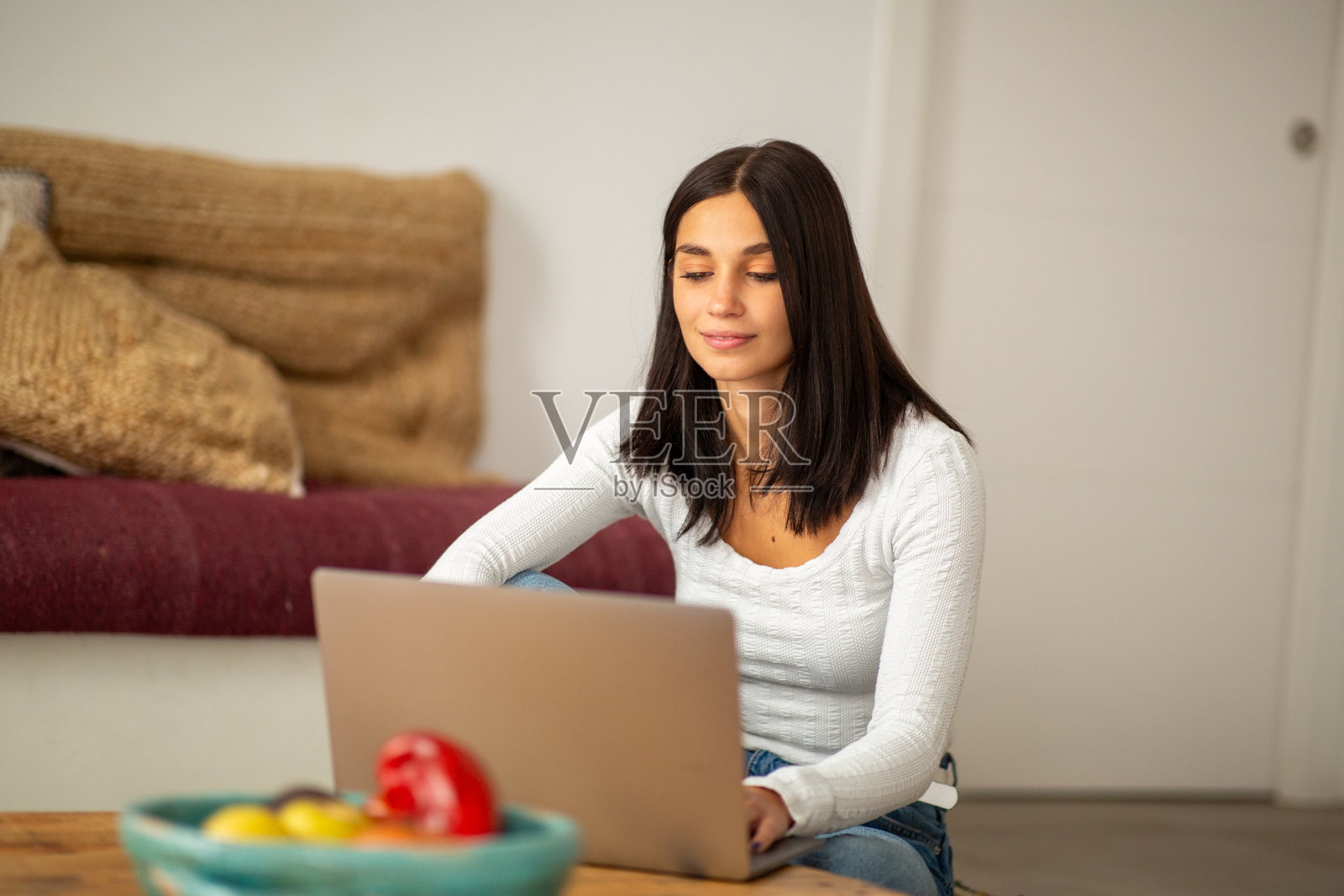 年轻女子坐在家里用电脑工作照片摄影图片