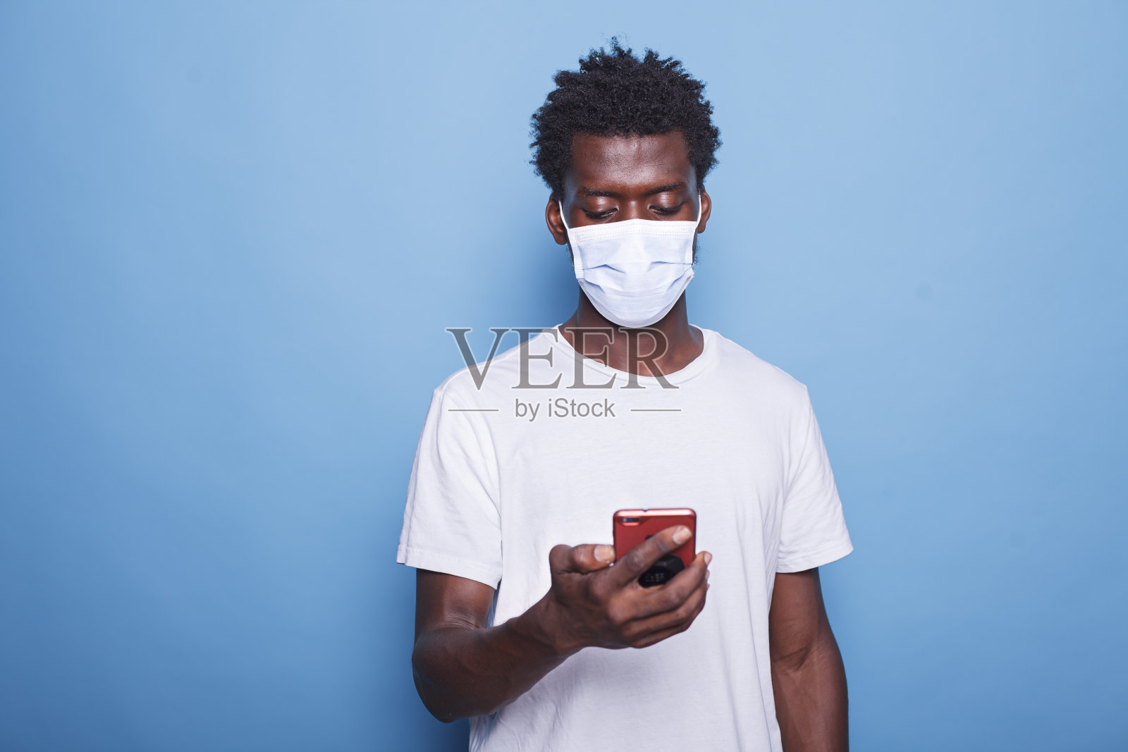 戴口罩的黑人男子使用智能手机照片摄影图片