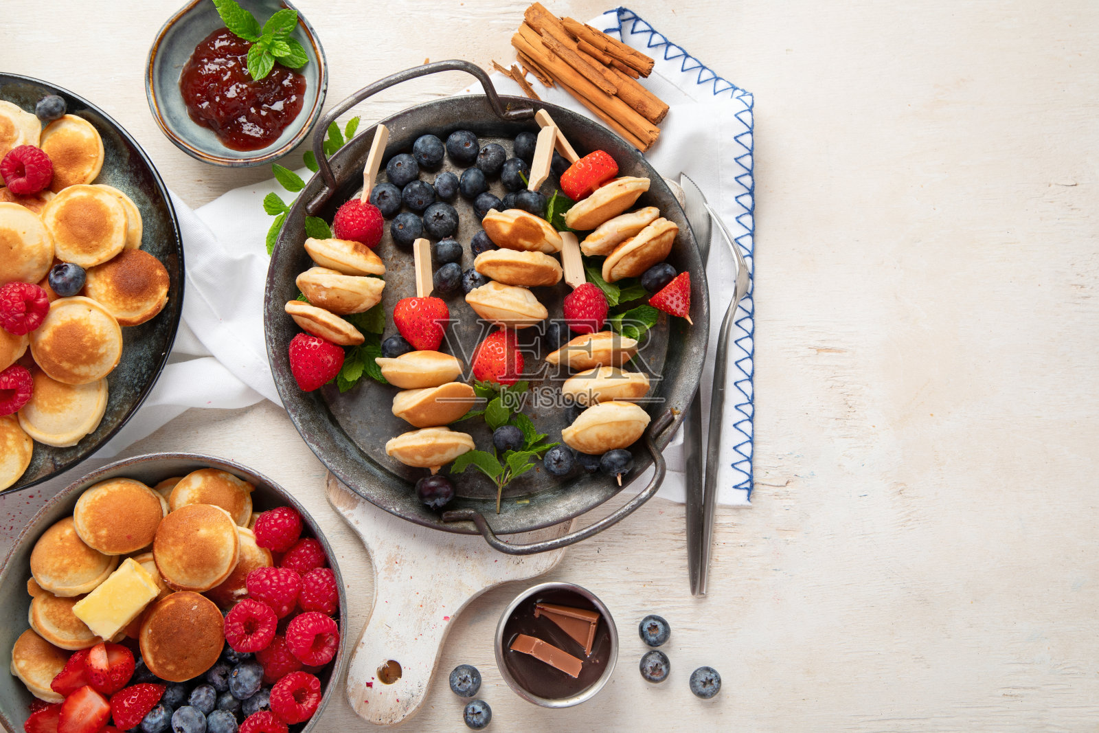 美味的蓝莓，草莓和覆盆子煎饼。甜美可口的早餐在浅色的背景照片摄影图片