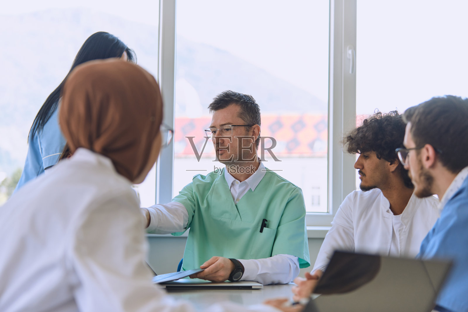 在医疗机构中，一组专门的医生和护士会认真倾听同事的工作计划，促进合作并确保高质量的患者护理照片摄影图片