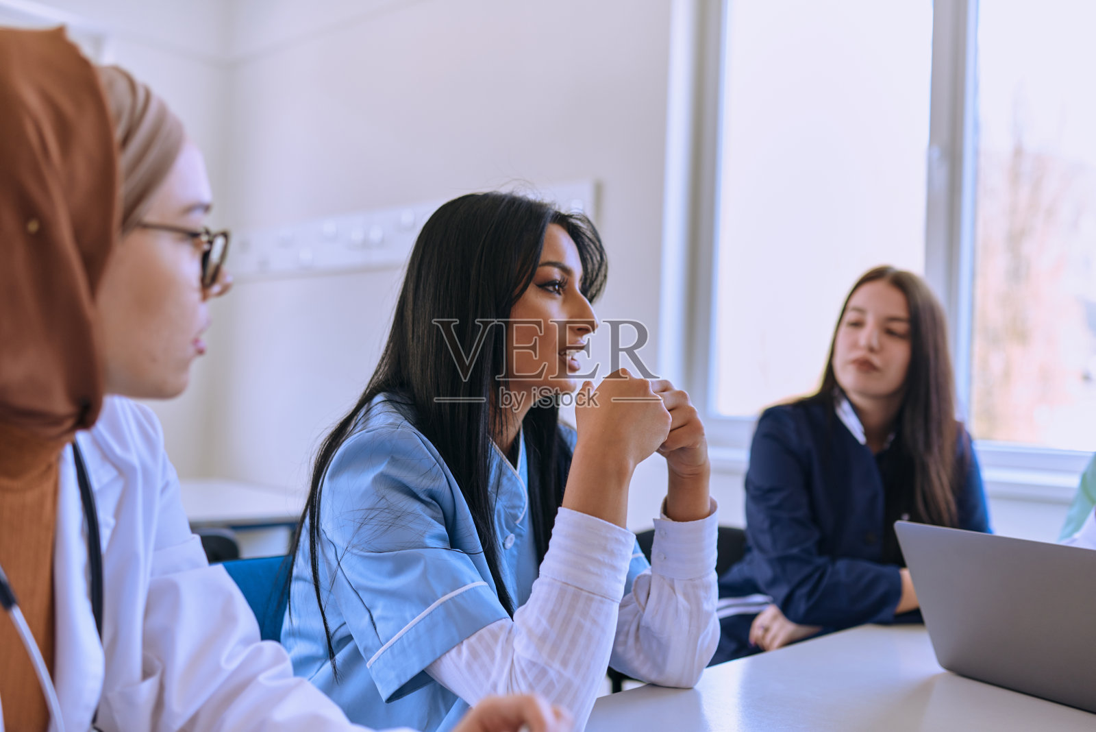 在医疗机构中，一组专门的医生和护士会认真倾听同事的工作计划，促进合作并确保高质量的患者护理照片摄影图片