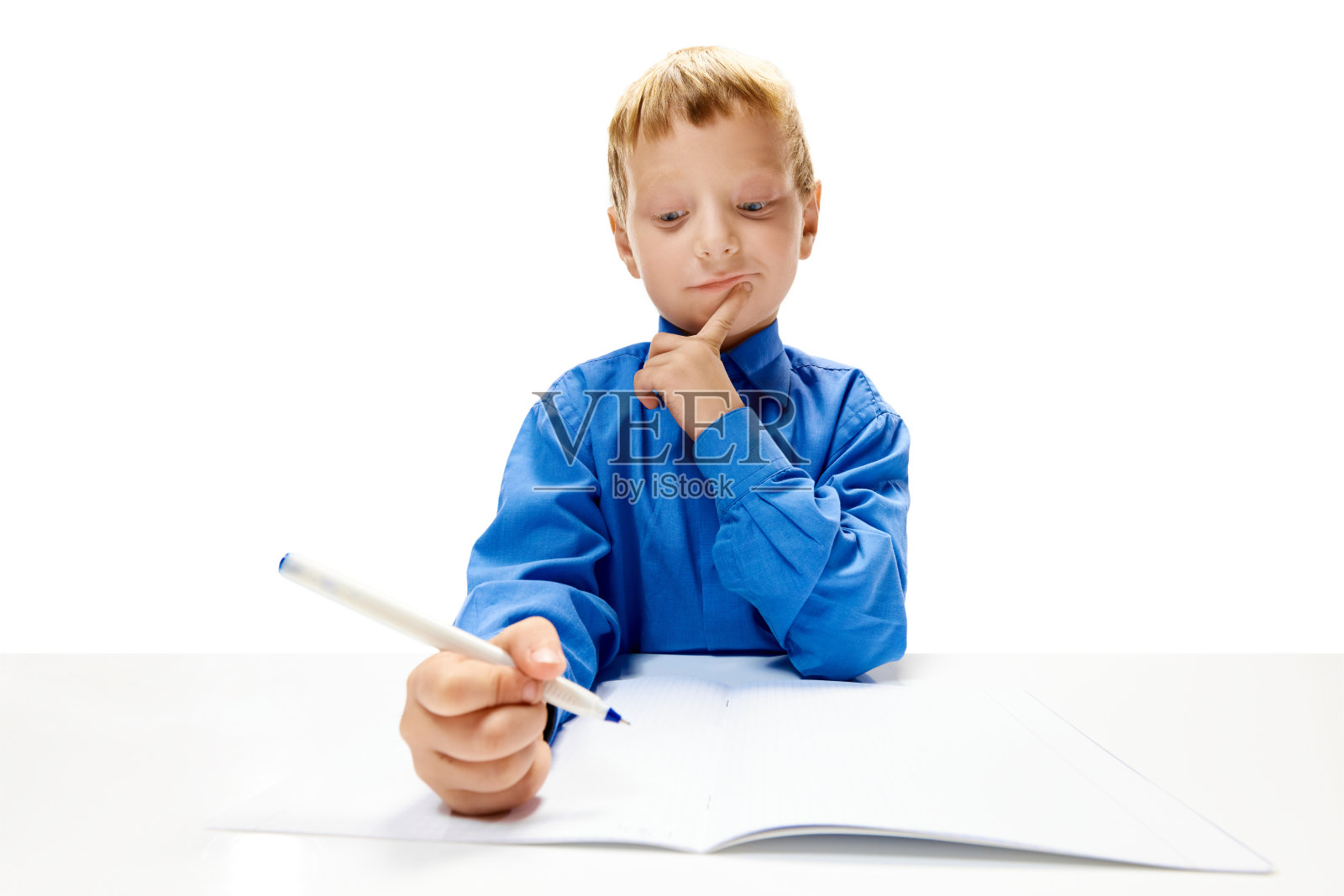 小学班的小男孩在抄写本上做作业。学龄前儿童学习和学习。在线教育照片摄影图片