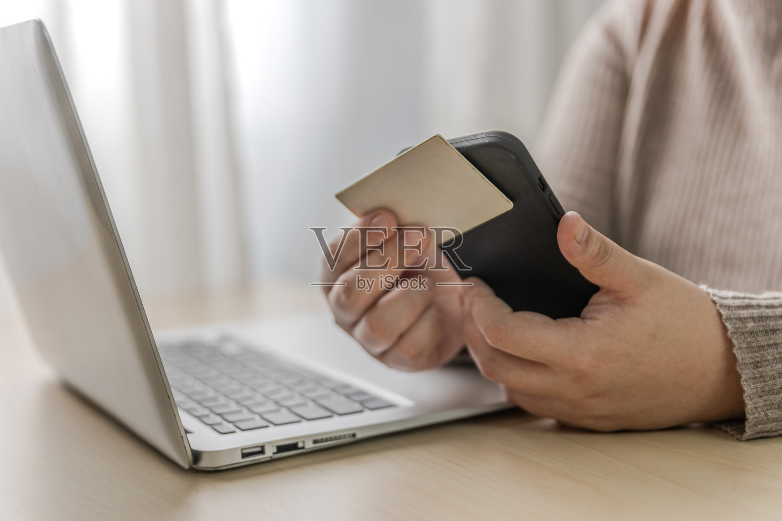 女性在家办公，使用笔记本电脑、智能手机和非接触式支付照片摄影图片