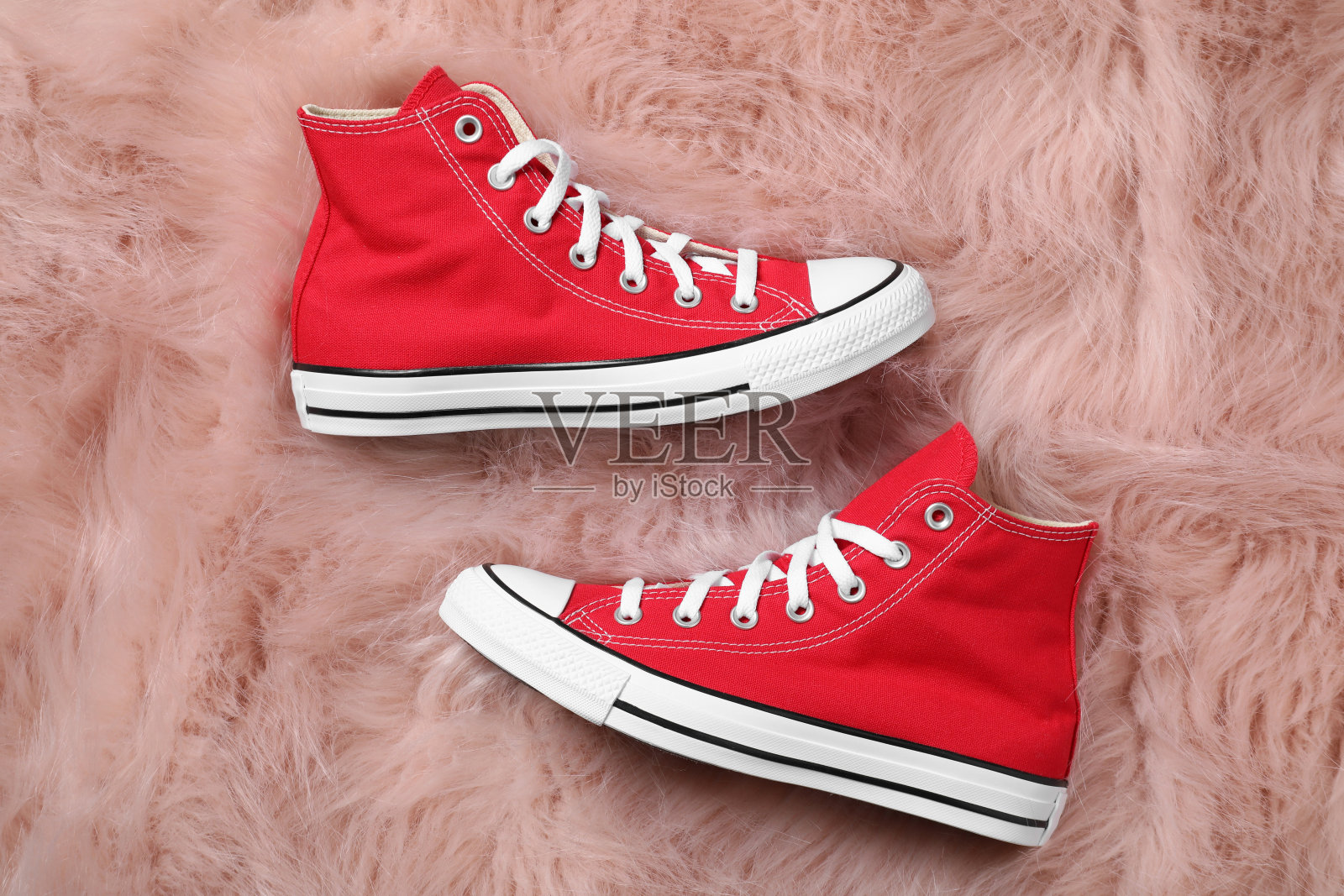 一双时髦的红色鞋子，铺在人造毛皮地毯上，平铺着照片摄影图片