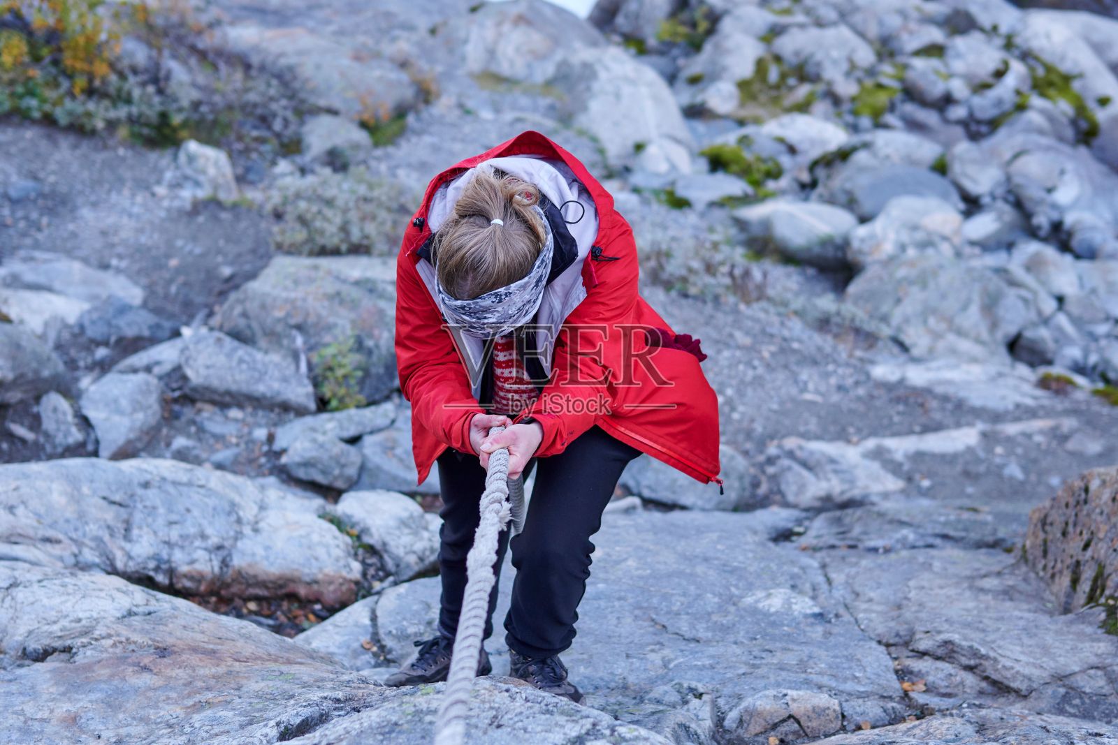 一名女徒步旅行者正在攀登挪威布尔布林冰川上的悬崖峭壁照片摄影图片
