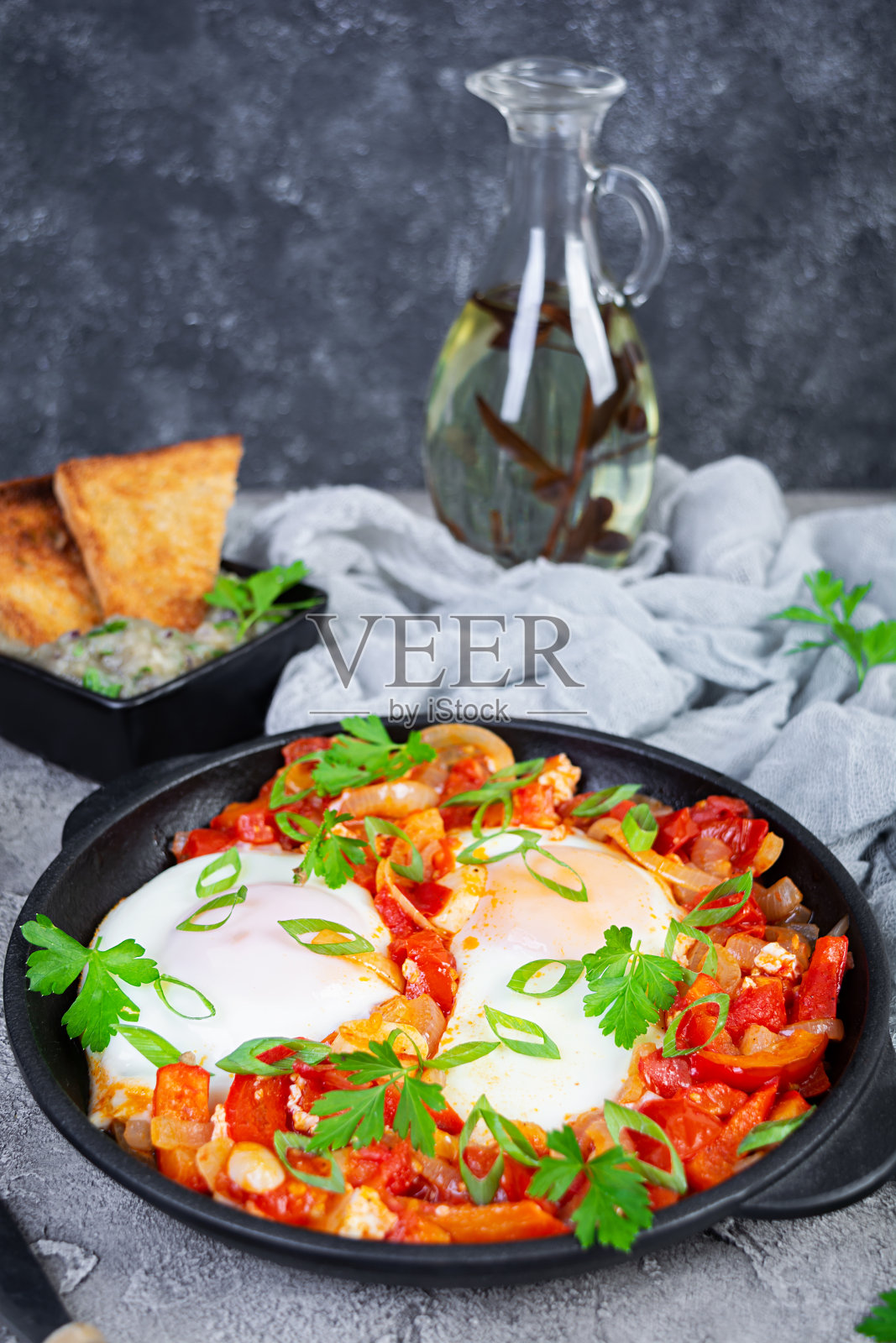 沙克舒卡配烤面包。番茄、辣椒、大蒜和香草煎蛋照片摄影图片