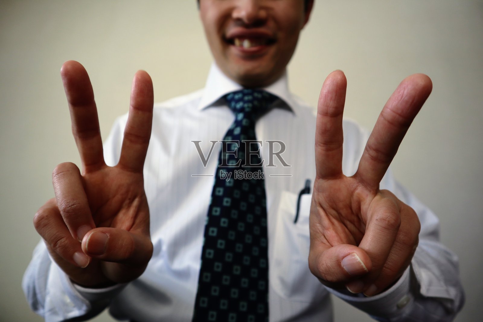 商人做和平手势的特写照片摄影图片