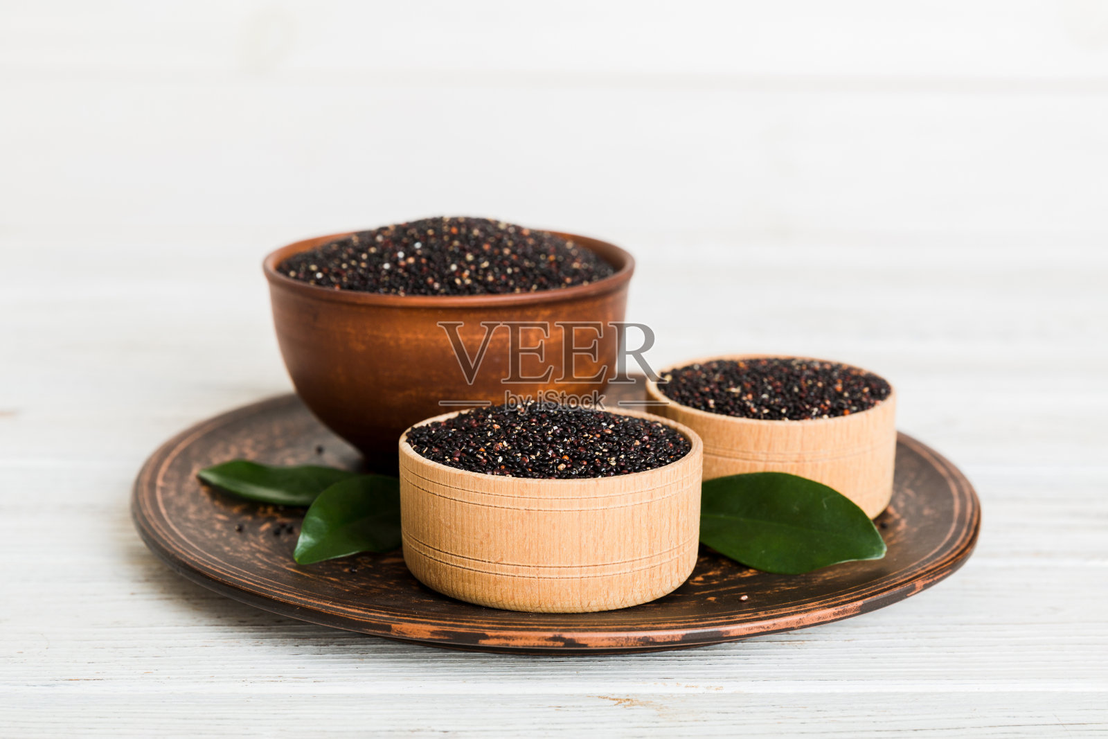 碗里的藜麦种子，背景是彩色的。小碗里的健康金蛙。健康的超级食物照片摄影图片