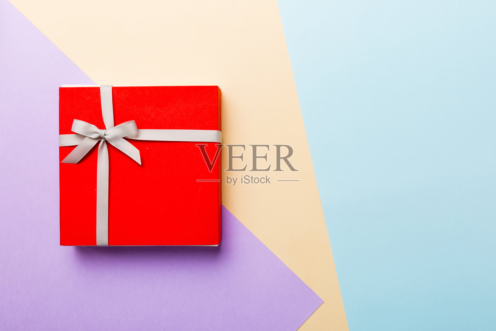 假日手工礼物系灰丝带蝴蝶结顶视图与复制空间。平铺假日背景。生日或圣诞礼物。圣诞礼盒概念与复制空间照片摄影图片