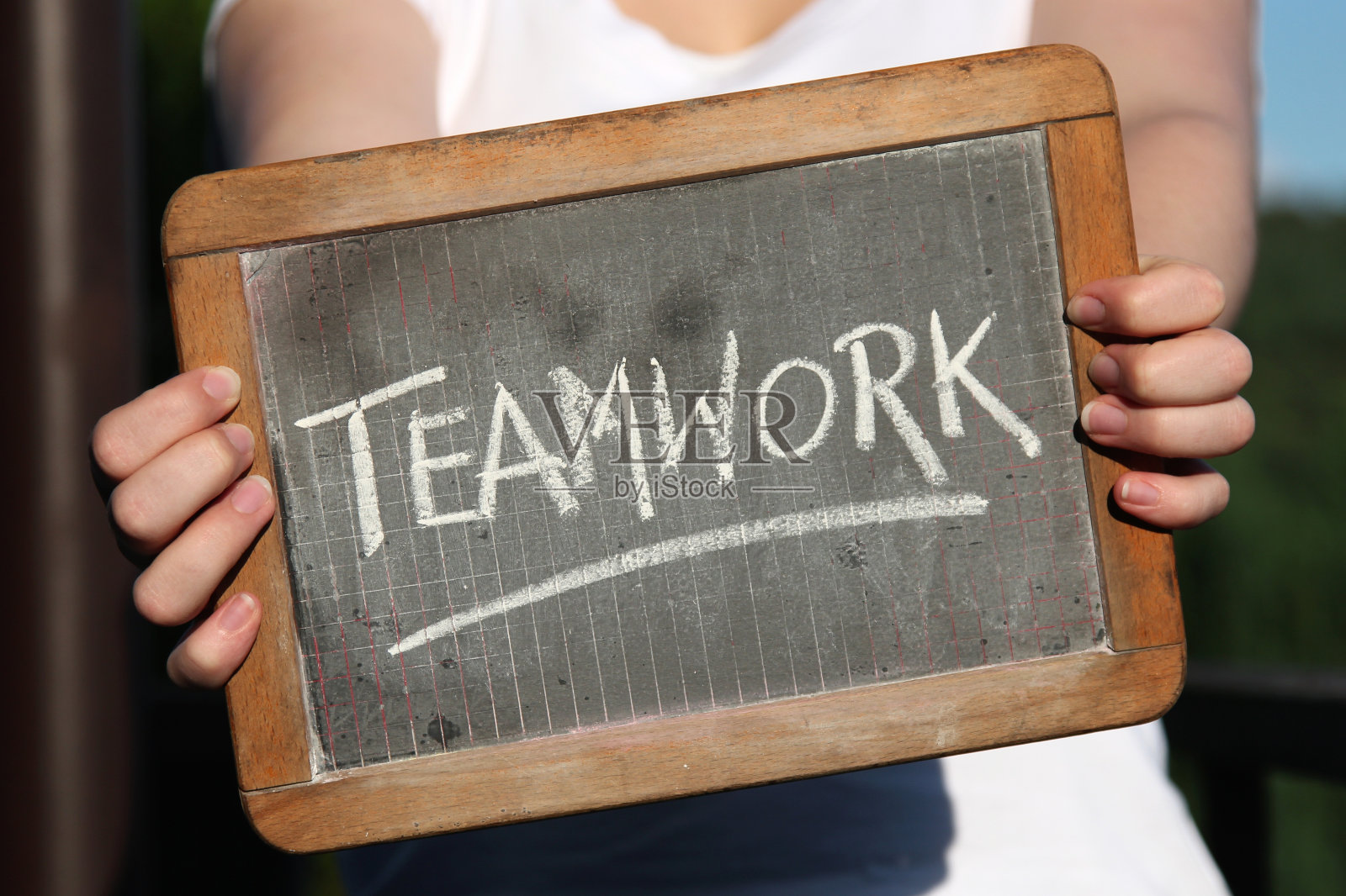 图为年轻女性用粉笔在石板上书写的团队合作照片摄影图片