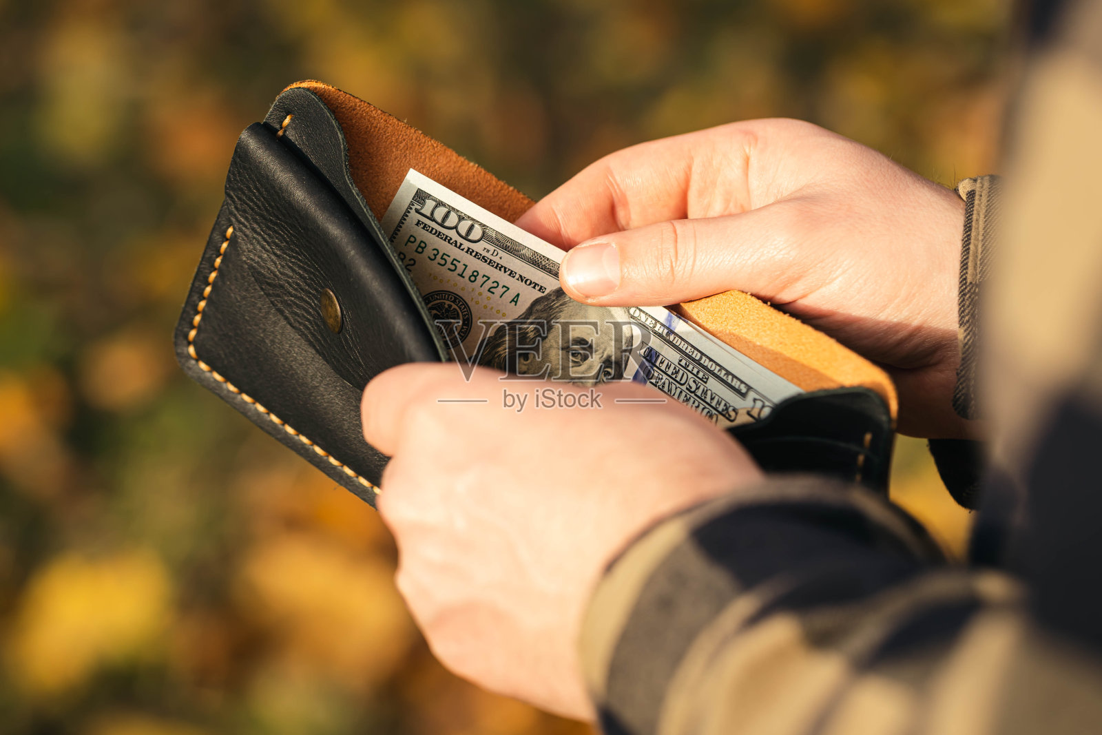打开钱包，男人手里拿着钞票，特写。照片摄影图片