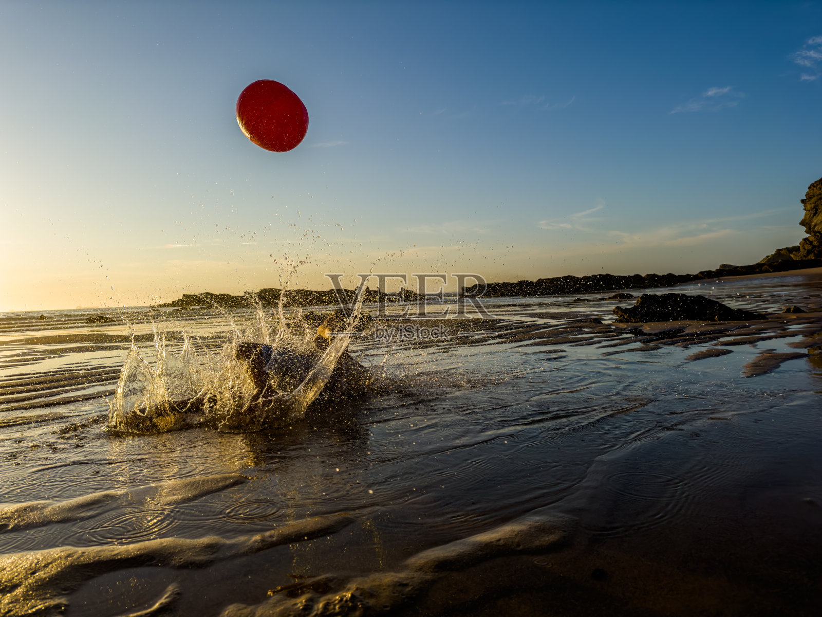 葡萄牙，一个孩子在海边玩红球照片摄影图片