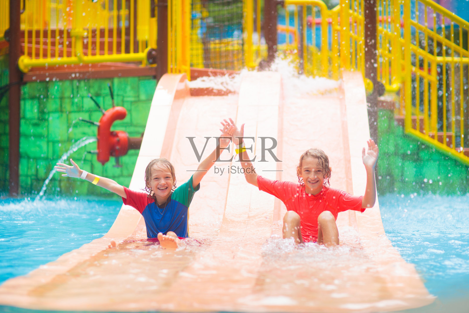 孩子们在水上滑梯上。一家人在水上主题公园。照片摄影图片