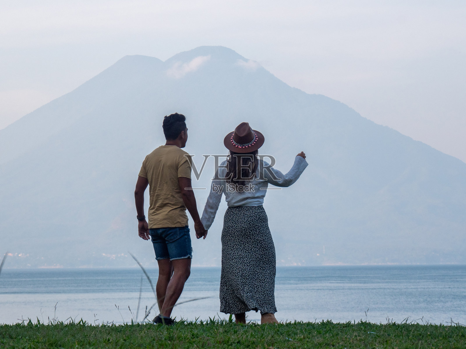 多种族夫妇在湖边凝视火山照片摄影图片