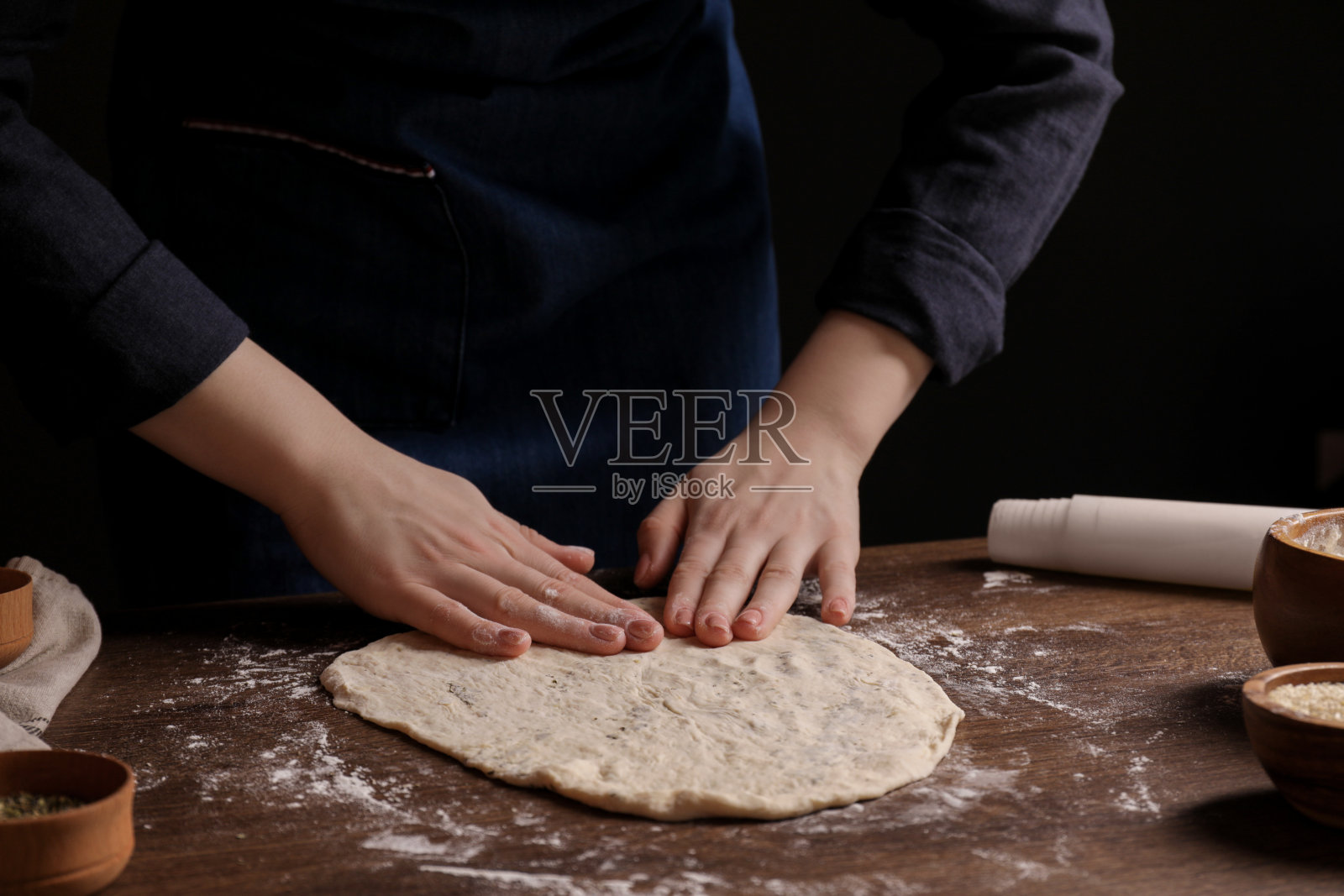 木桌旁做格里西尼的女人，特写照片摄影图片