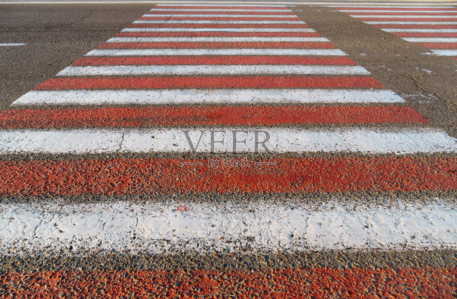 行人过路标志，柏油路上的红白线为背景照片摄影图片