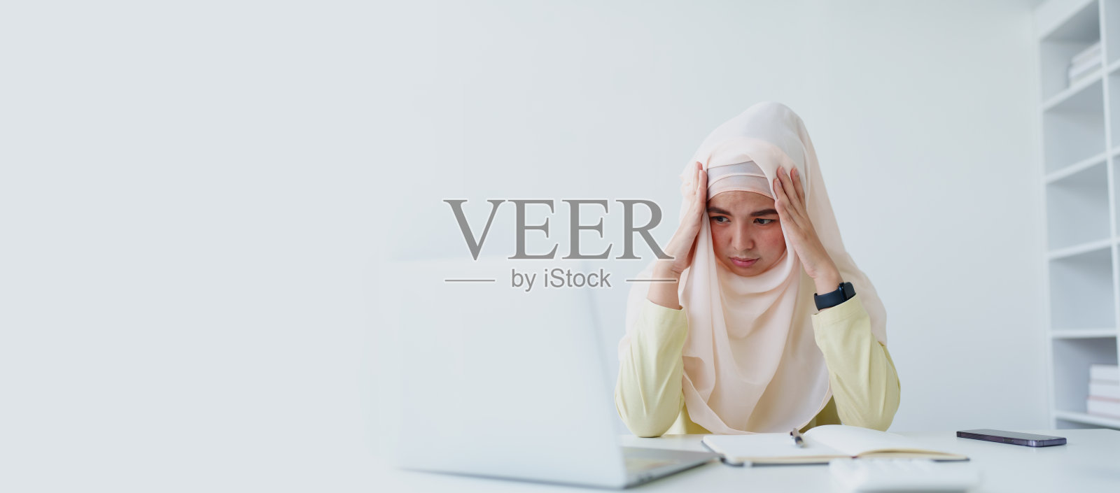 穆斯林女性员工在办公室工作倦怠。照片摄影图片