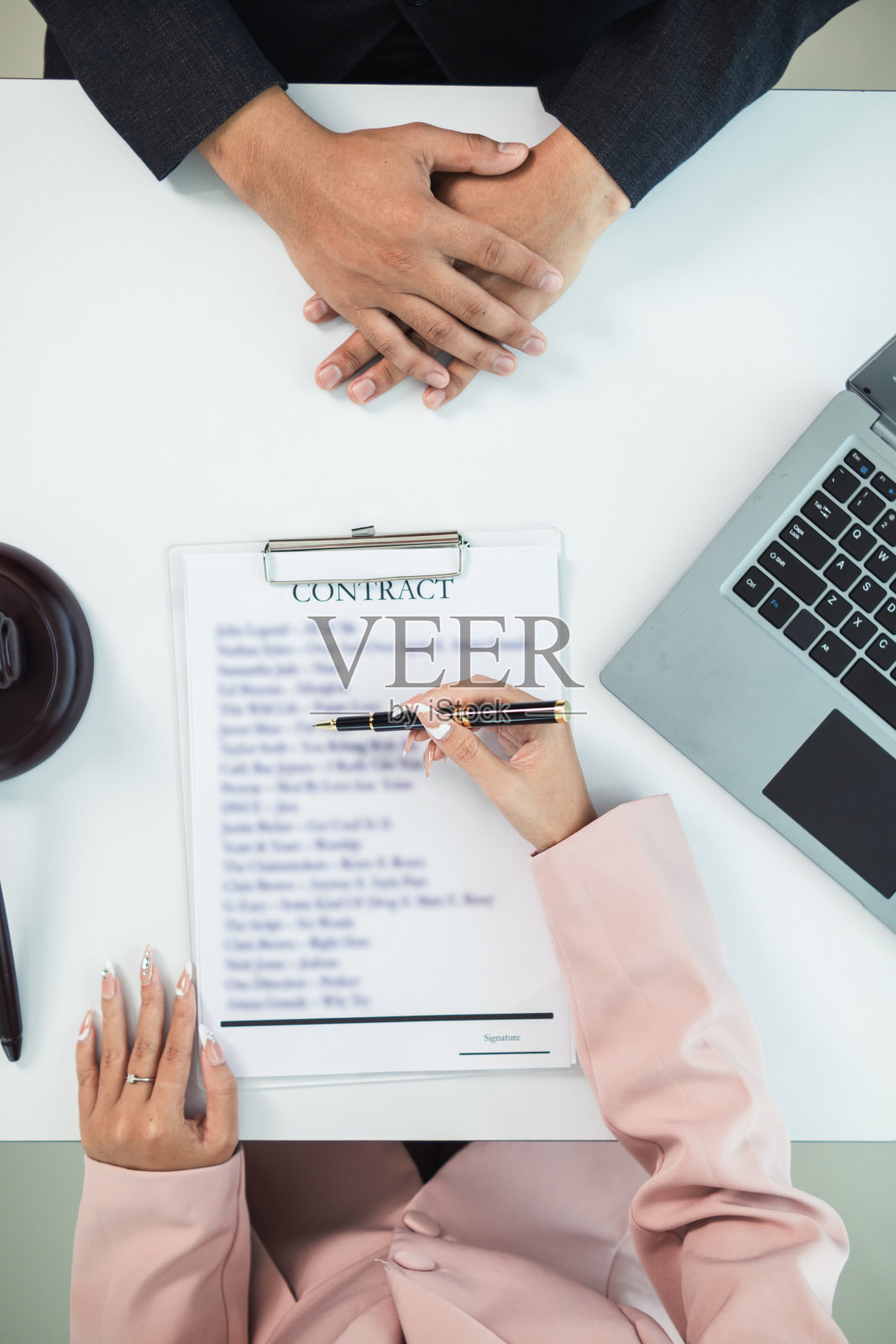 销售合同被放在律师事务所的桌子上，因为公司聘请律师事务所作为法律顾问，起草合同，以便客户签署正确的合同。照片摄影图片