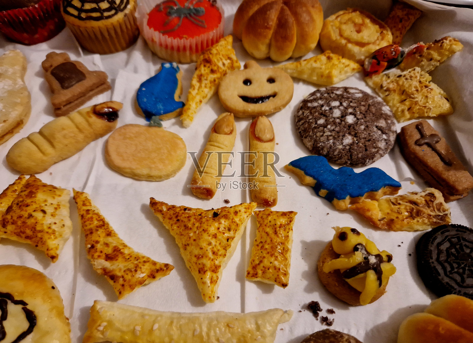 万圣节饼干。裹在面团里的多肉公园就像木乃伊。他们也有一张辣脸。其他的甜点是孩子们烤的。他们用扁桃体、指甲和血、果酱割伤手指照片摄影图片