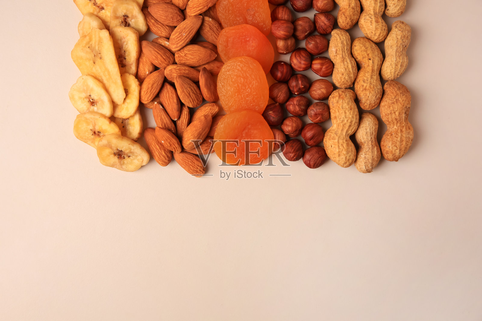 混合了美味的干果和水果，米色的背景，平铺。文本空间照片摄影图片