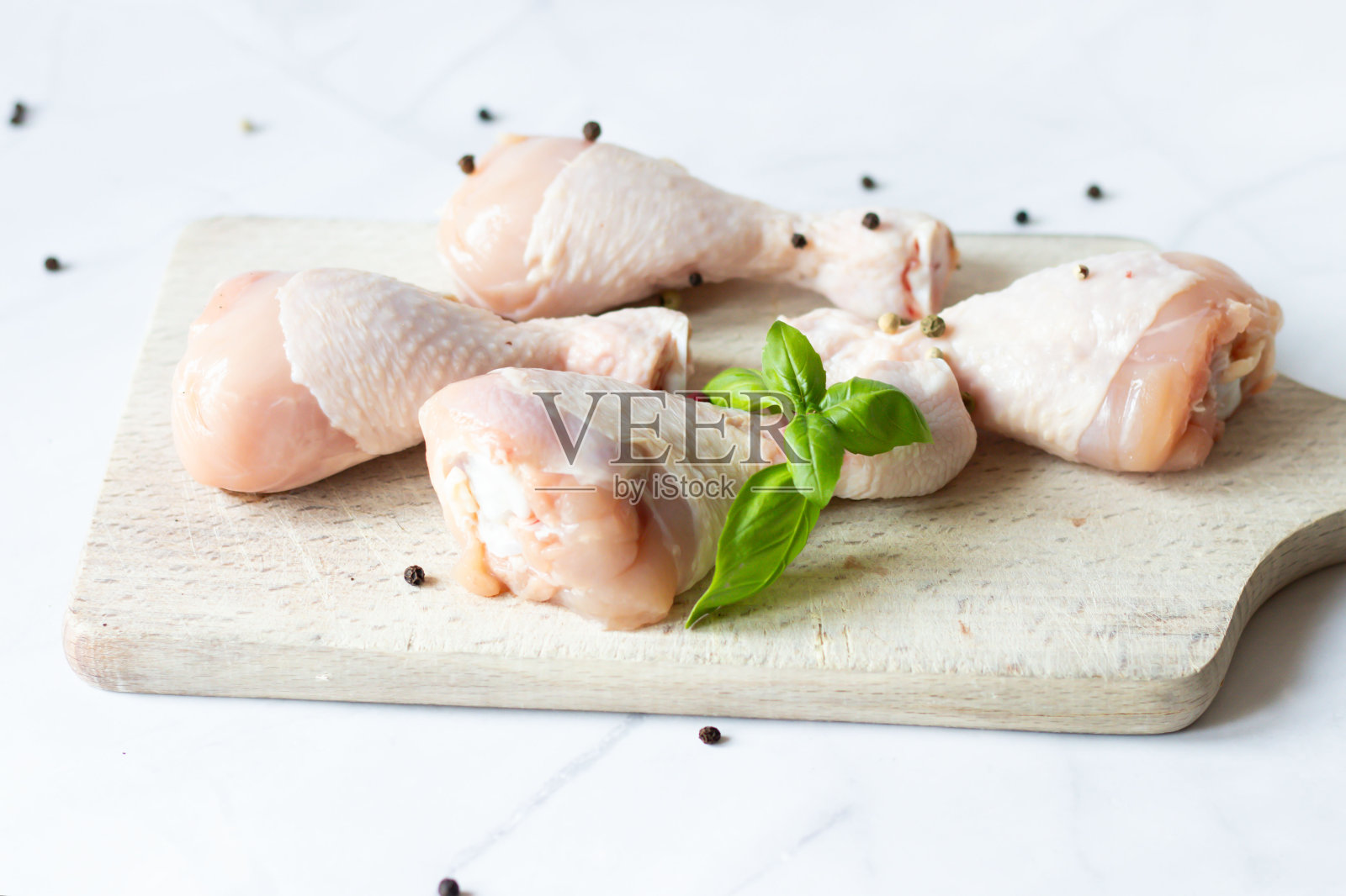 加香料和香草的生鸡腿。在白色的背景上。食物照片摄影图片