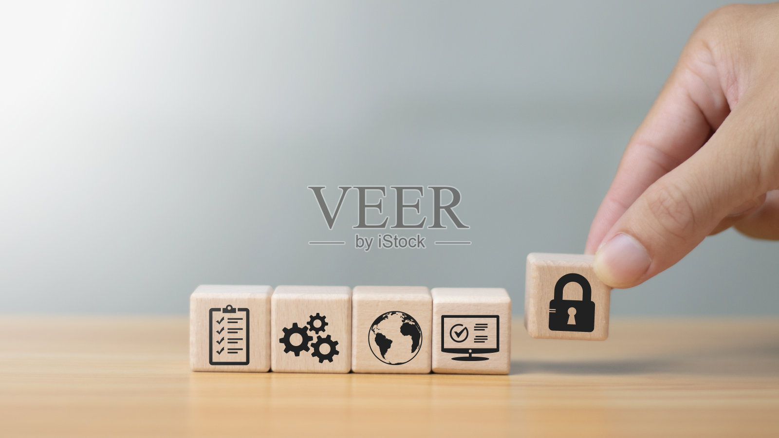 数字网络犯罪保护概念保护数据免受黑客攻击，手持带键图标的木制立方体。照片摄影图片