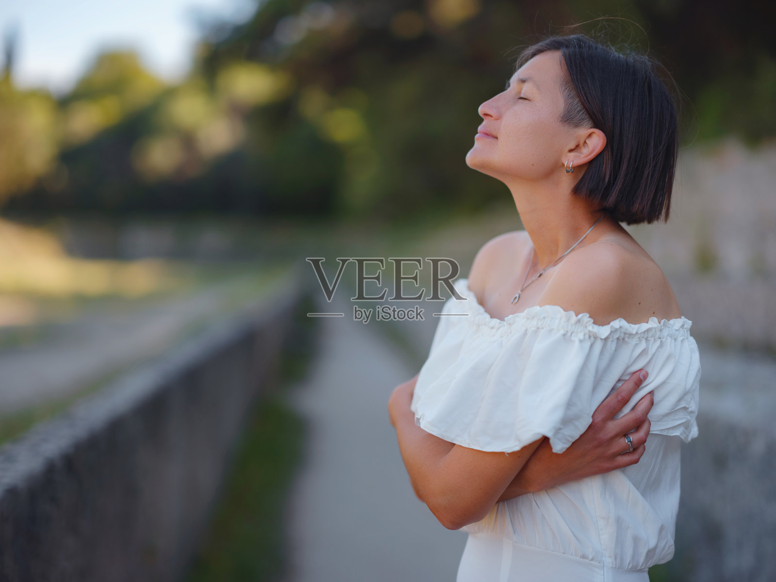 美丽的亚洲年轻女子在户外穿着白色连衣裙照片摄影图片