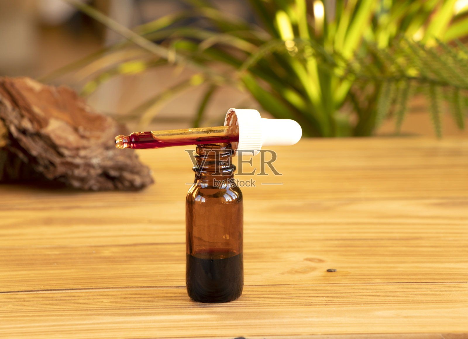 一滴血清用移液管滴在一个棕色的玻璃罐里照片摄影图片