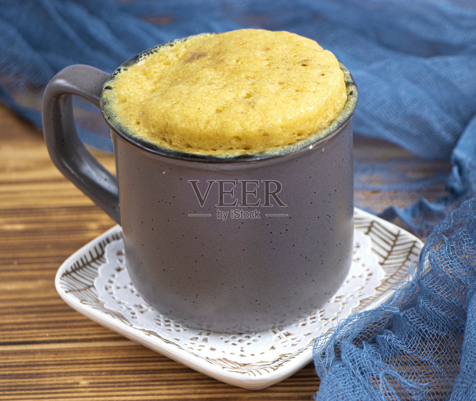 香草蛋糕是微波炉加热的。用咖啡杯装的自制纸杯蛋糕。照片摄影图片