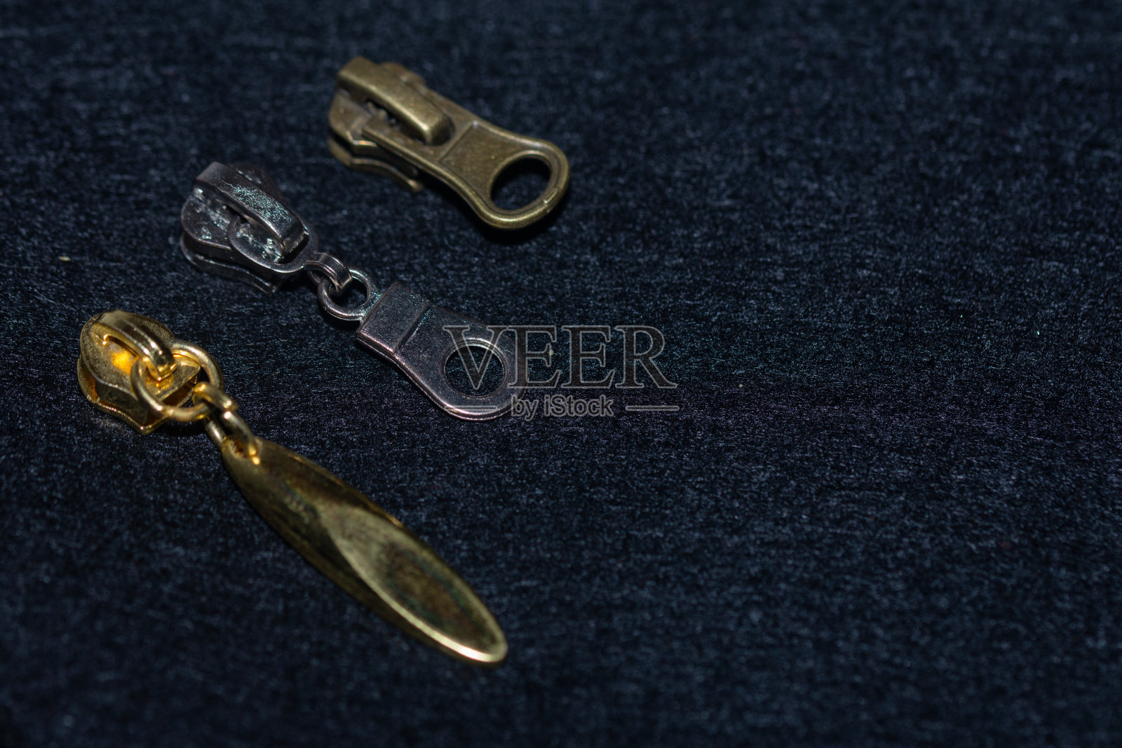 尼龙，塑料和金属拉链的金属滑块。照片摄影图片