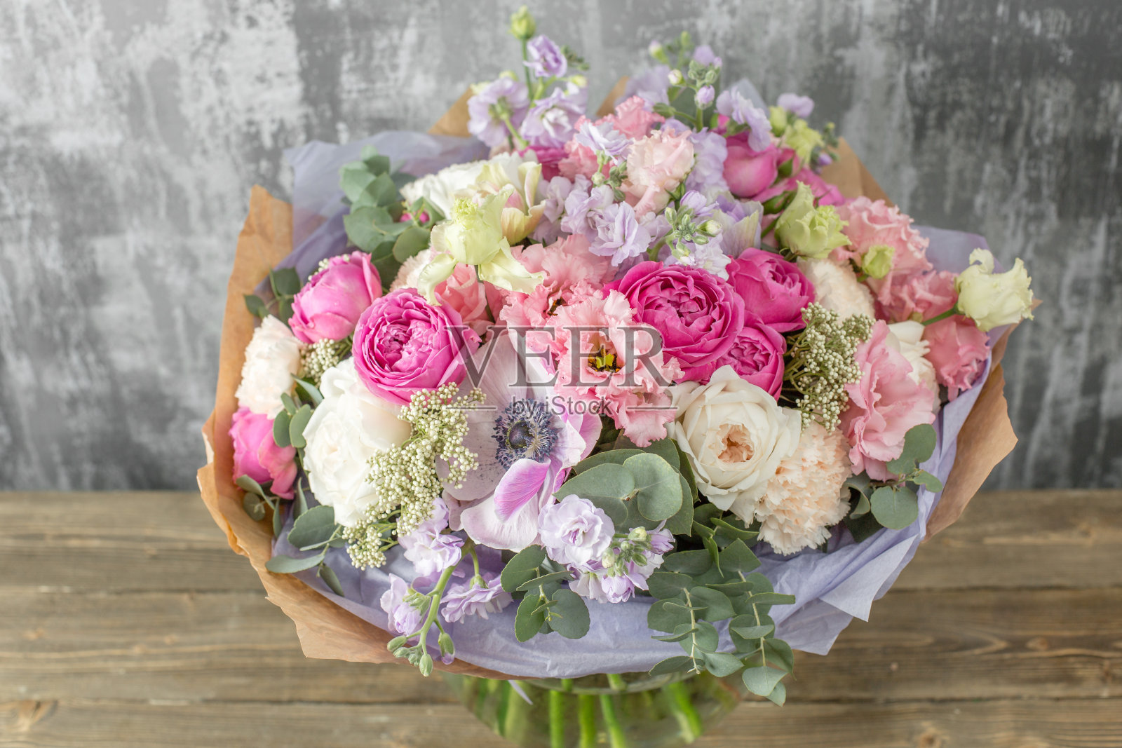 女人手里拿着一束美丽的混合花。花店概念。美丽新鲜的花束。鲜花交付照片摄影图片