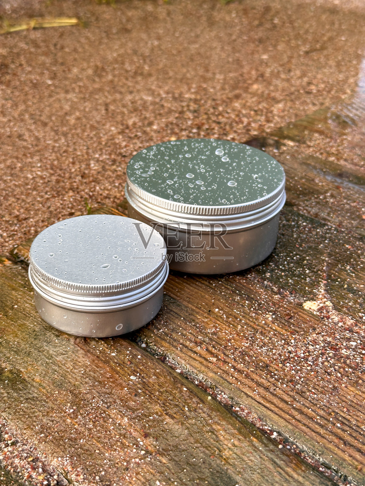 大大小小的银罐放在木架上，四周洒水，喷水照片摄影图片