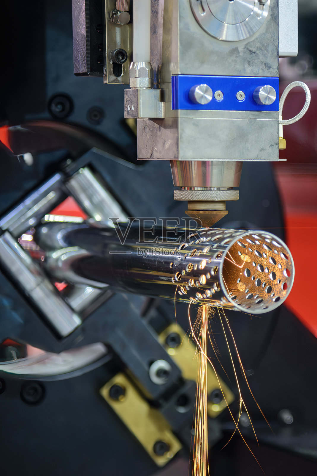 垂直场景光纤激光切割机切割不锈钢管，发出闪闪发光的光。照片摄影图片