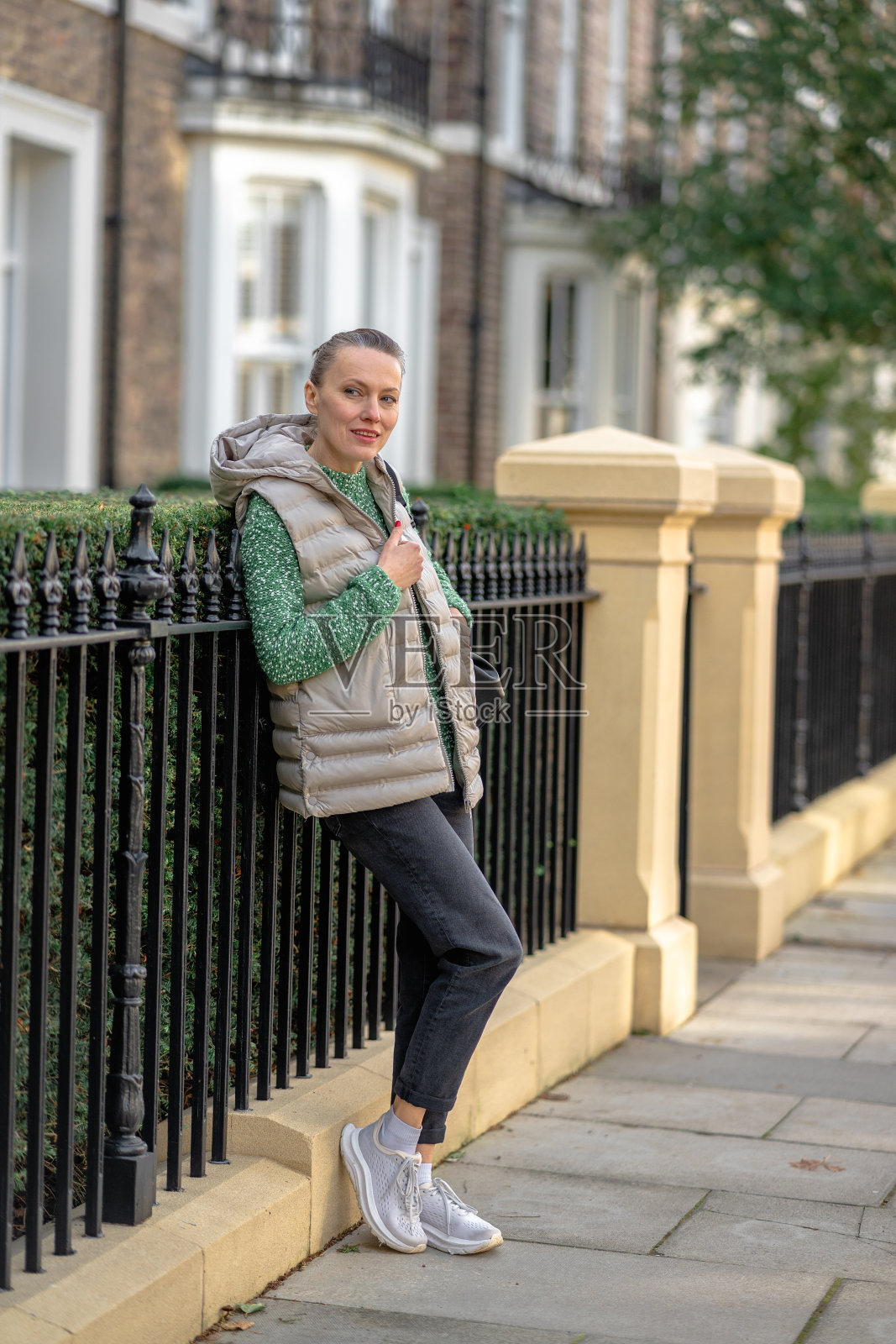 城市里穿着绿色毛衣的年轻女子的肖像照片摄影图片